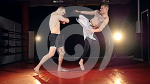 A fighter knocks down his assistant with a jump kick.