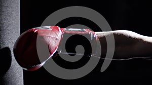 Fighter Practicing Some Kicks With Punching Bag - A Man With A Tattoo Boxing On dark Background. Kick, punching bag on