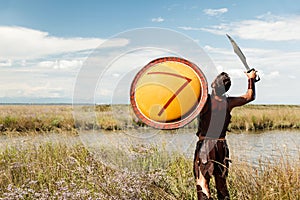 Fighting ancient warrior in landscape background