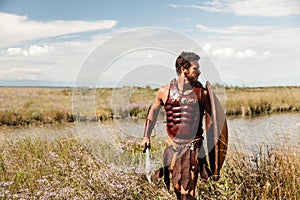 Fighting ancient warrior in landscape background