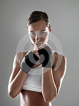 Fighting back against fat. Portrait of a young woman in a boxer stance.