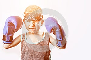 Fighting boy in Boxing gloves and bandana on light background