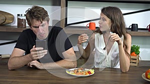 Fighting Caucasian couple smart phone addict problem while eating dinner