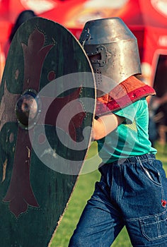 Fighting child wearing shield and helmet