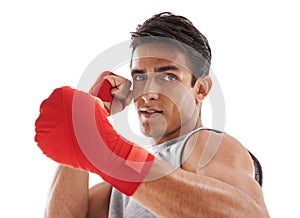 Fighting fierce. Portrait of a handsome young kick-boxer punching against a white background.