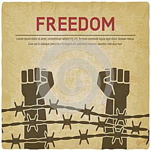 Fighting for freedom concept. Hands clenched into fist behind barbed wire vintage background