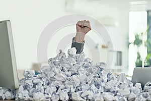 Fighting his way through the paperwork. an unidentifiable businessman drowning under a pile of paperwork in the office.