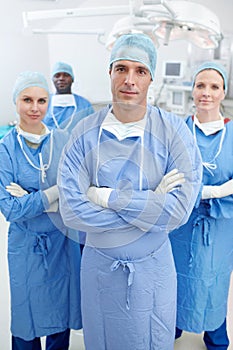 Fighting for your health and wellbeing. Portrait of a serious team of medical surgeons standing in an operating theatre.