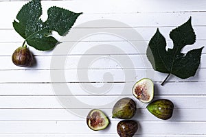 Figs and leaves on a wooden background