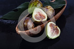 Figs with leaves in a wooden plate