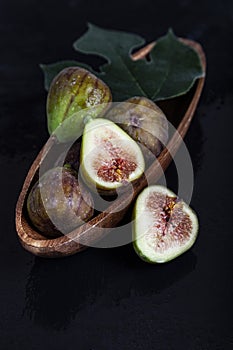 Figs with leaves in a wooden plate