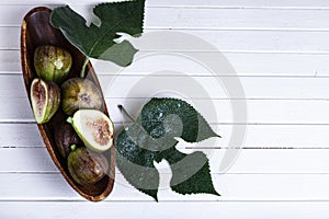 Figs with leaves in a wooden plate