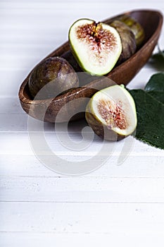 Figs with leaves in a wooden plate