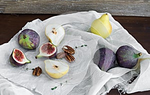 Figs, pears and pekan nuts on a white tissue photo