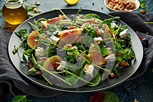 Figs salad with blueberries, walnuts, feta cheese and green vegetables. healthy food