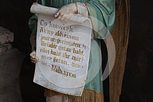 Figure of an angel holding a scroll with one of Jesus parables photo