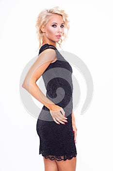 figure of a beauty young blonde woman posing in black short elegance dress