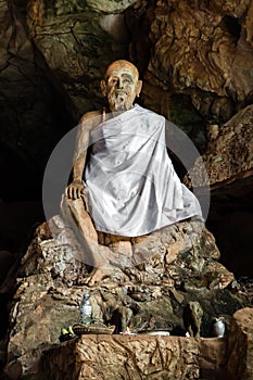A figure of Buddhist monk in the cave, Thailand