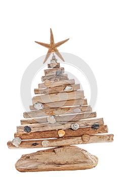 The figure of a Christmas tree made of wood and shells, with a starfish. The concept of new year holidays at the resort. Isolate