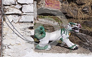 The figure of a fantastic dragon dog on the chain at the entrance to the Chagri Cheri Dorjeden Monastery, Buddhist monastery near photo