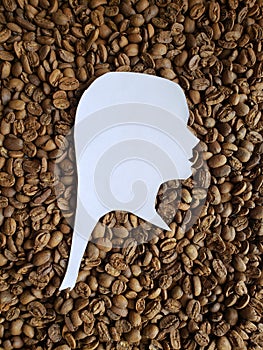 figure of a female human face of profile in white and background with roasted coffee beans