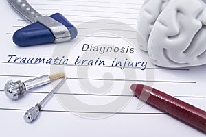 Figure of human brain, blue neurological reflex hammer, neurological needle and brush for test sensitivity and ballpoint pen lie o photo