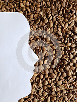 figure of a human face of profile in white and background with roasted coffee beans