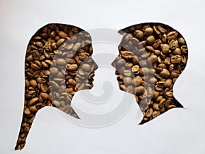 figure of a male and female human faces of profile with roasted coffee beans and white background