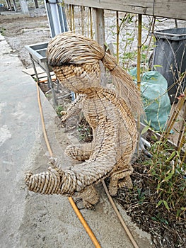 figure of a man sitting on the bench made of dried straw.