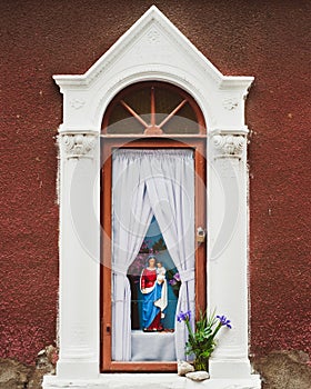 Figure of Mary holding Jesus in a outdoor shrine