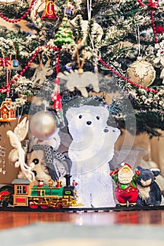 Figure of polar bear with bear cub under Christmas tree