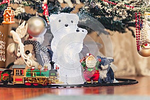 Figure of polar bear with bear cub under Christmas tree