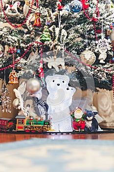 Figure of polar bear with bear cub under Christmas tree