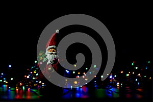 Figure of Santa Claus among the colourful Christmas lights