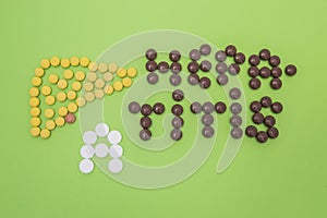 Figure or shape of human liver and the diagnosis of hepatitis A sign made of yellow, brown and white pills or tablets on a green p