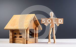 Figure of wooden man hold cubes with text sold. Property for sale