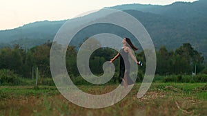 A figure of a young woman with a retro camera spinning around in nature