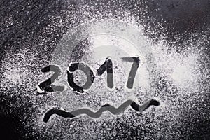 Figures 2017 on flour spilling on black metal background