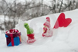 Figures of a boy and a girl in the winter, a figurine of the heart and a gift box, a Valentine`s day.