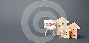 Figures of houses and an easel with the word Lockdown. Tough measures to stop new infections of coronavirus COVID-19 exponential