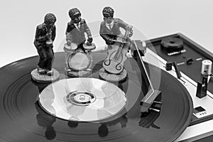 Figures of musicians on a vinyl record on an old record player