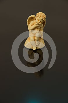 A figurine of an angel of a child with wings of yellow clay on a