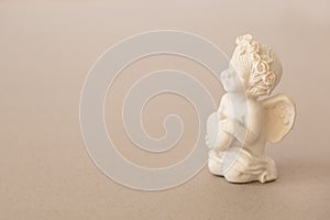 figurine of an angel Cupid with a bow on a pink background. Valentine's Day.