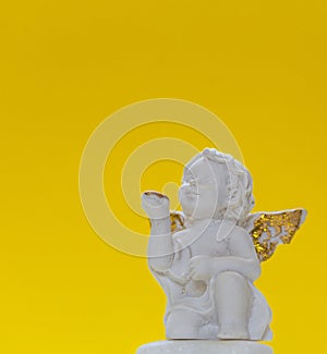 Figurine Of Baby Angel On Yellow Background 1