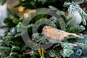 A figurine of a bird on a branch of a Christmas tree