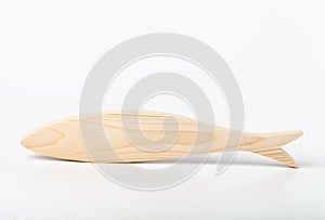 A figurine of a fish or horse mackerel, carved from solid pine with a hand jigsaw. On a white background