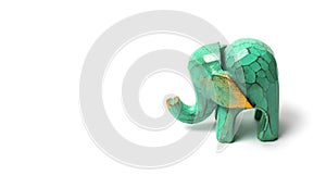 Figurine of a green wooden elephant with gilding isolated on white background. Decorative figurine of an elephant, hand