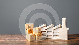 Figurine of industrial factory plant and cardboard boxes of goods and products. Manufacturing and production