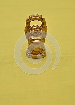 Figurine of a laughing and cheerful golden Buddha