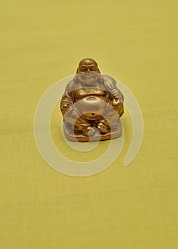 Figurine of a laughing and cheerful golden Buddha